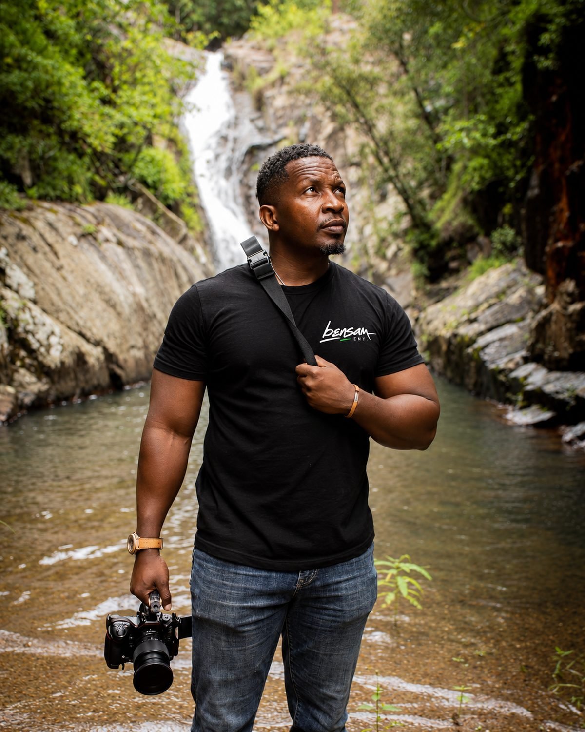 Bensam on location by a waterfall, camera in hand
