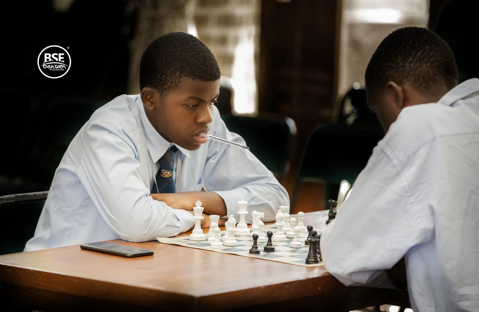 Two students over a chess board mid-game