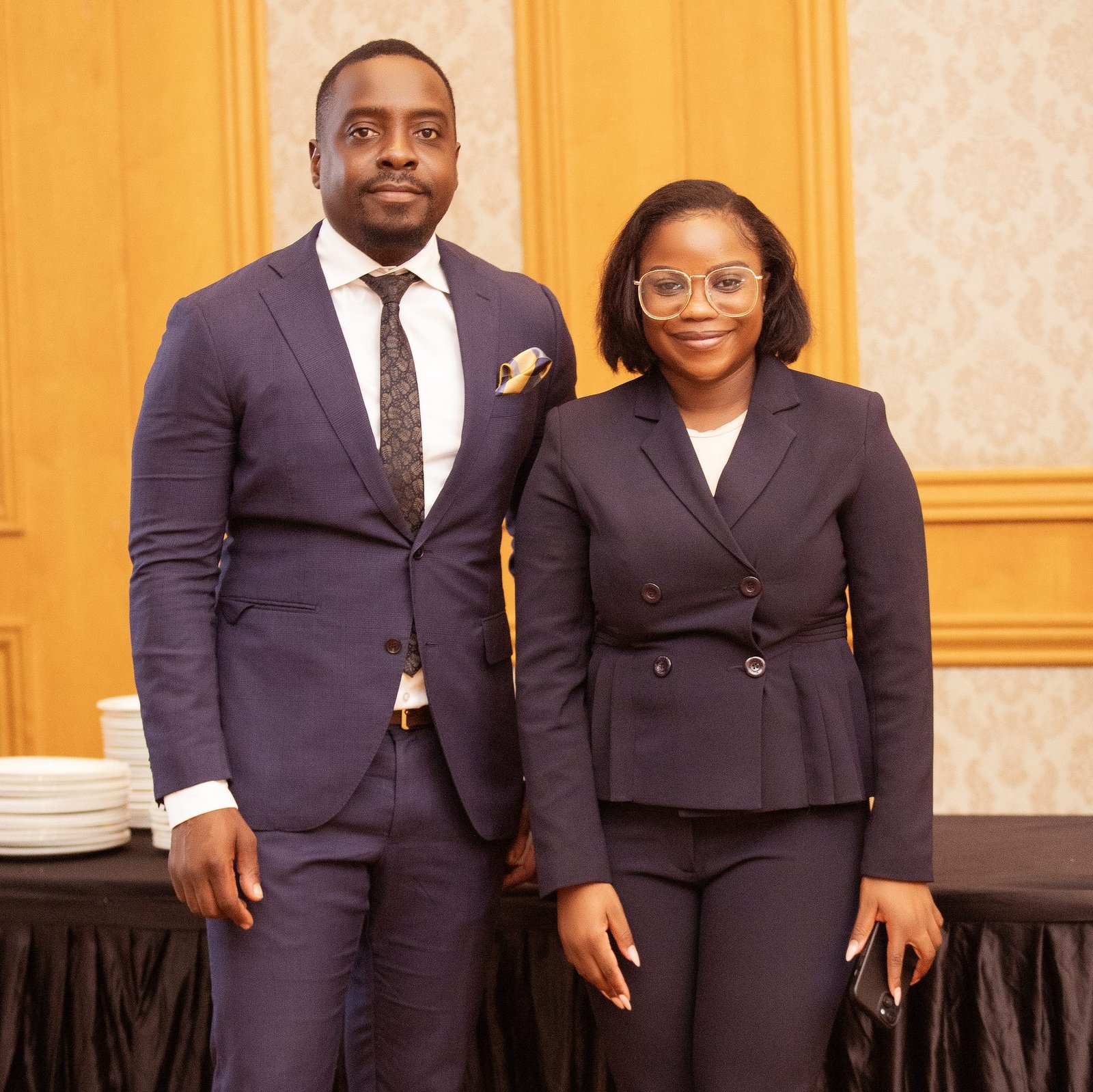 Two colleagues in dark suits at an event